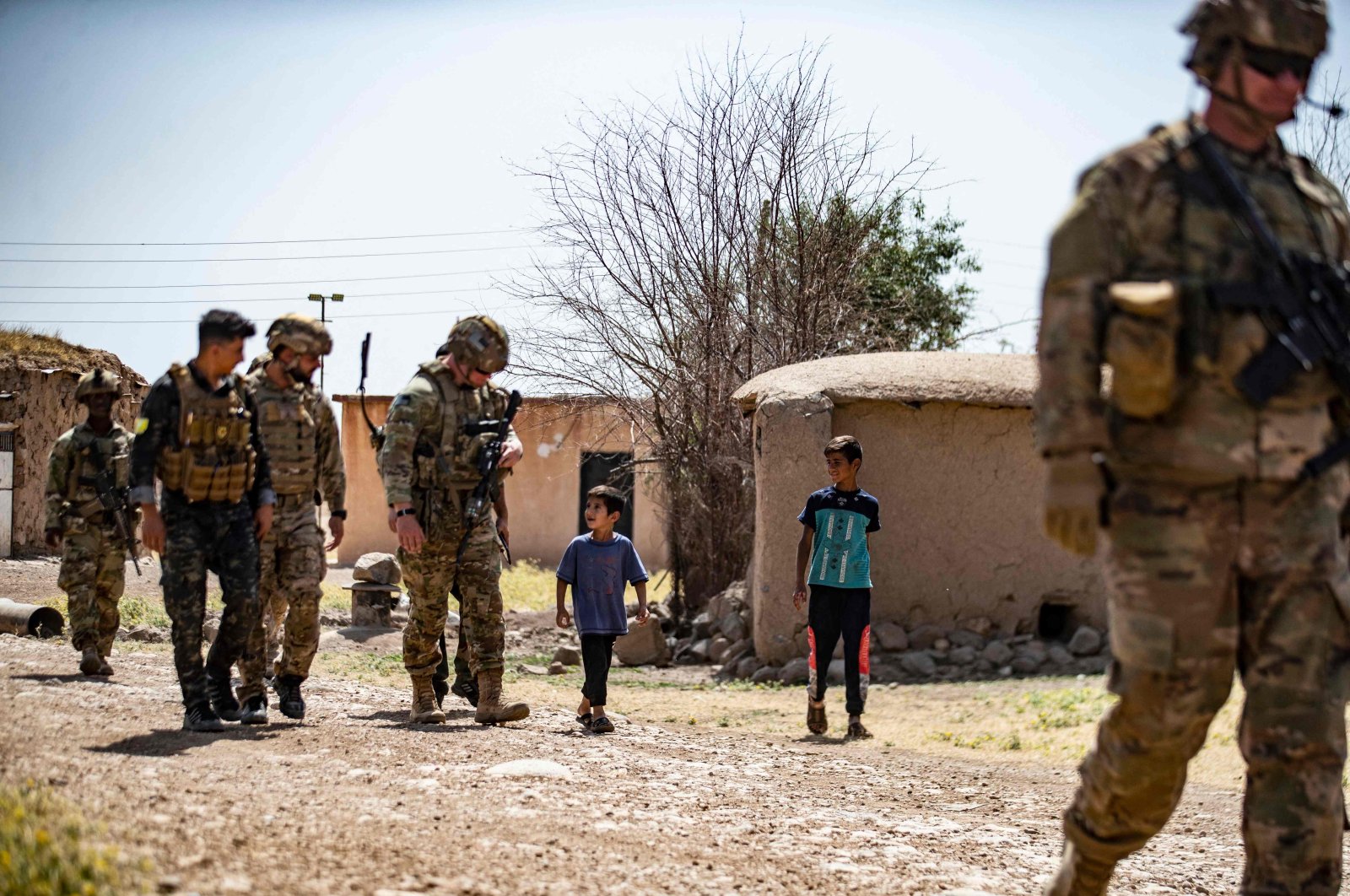 American soldiers patrol a village in the countryside of the Kurdish-majority city of Qamishli, northeastern Hassakeh province, Syria, June 12, 2022. (AFP Photo)
