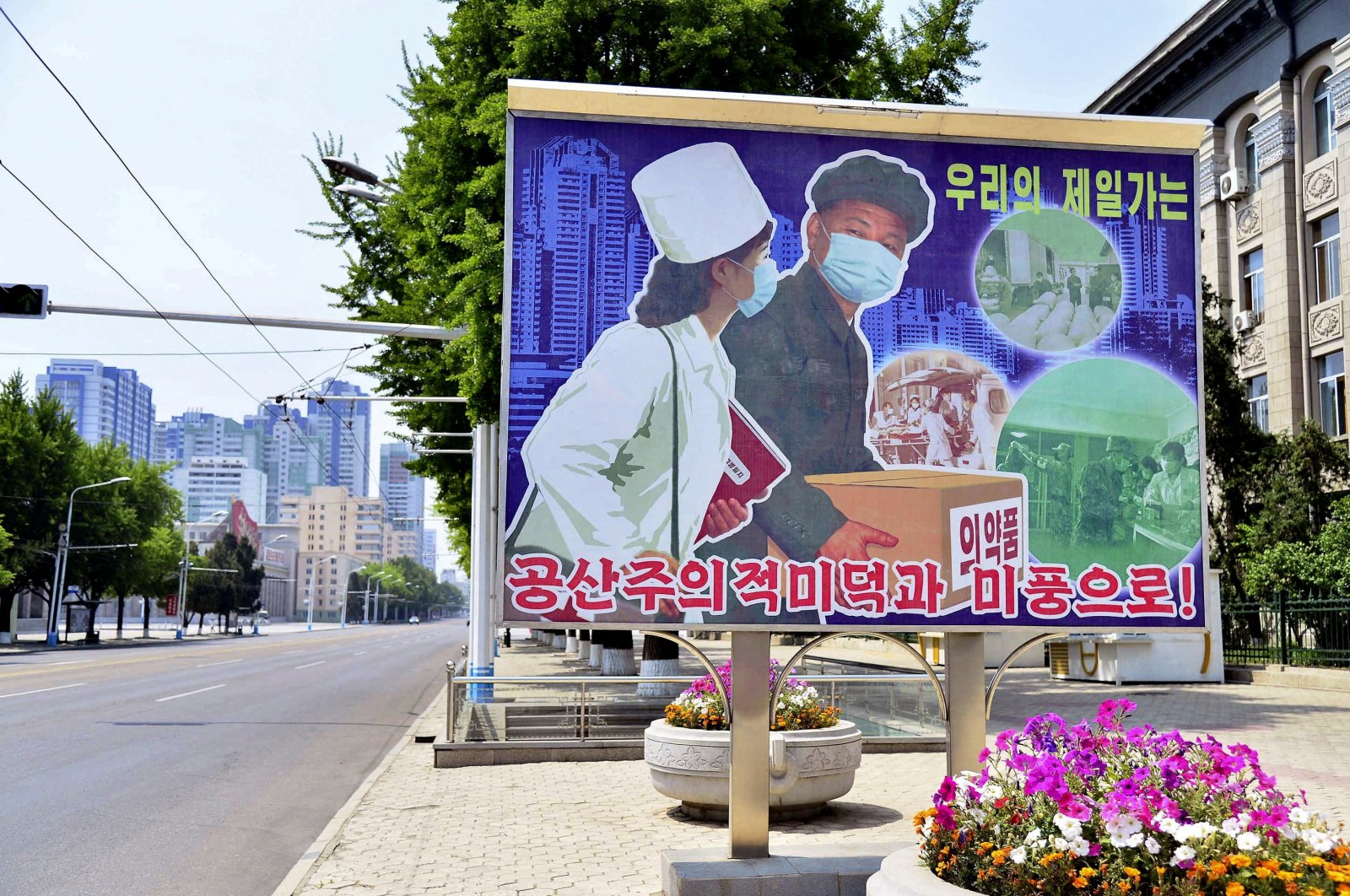 A sign depicting a scene of medical products transportation is displayed at the empty street, amid growing fears over the spread of COVID-19, Pyongyang, North Korea, May 23, 2022. (Kyodo via Reuters)