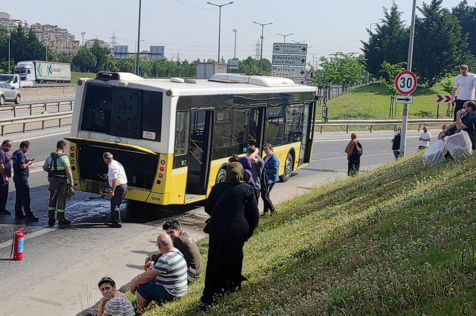 Passengers wait on the roadside after a bus broke down in the Kartal district, in Istanbul, Turkey, May 30, 2022. (AA PHOTO)