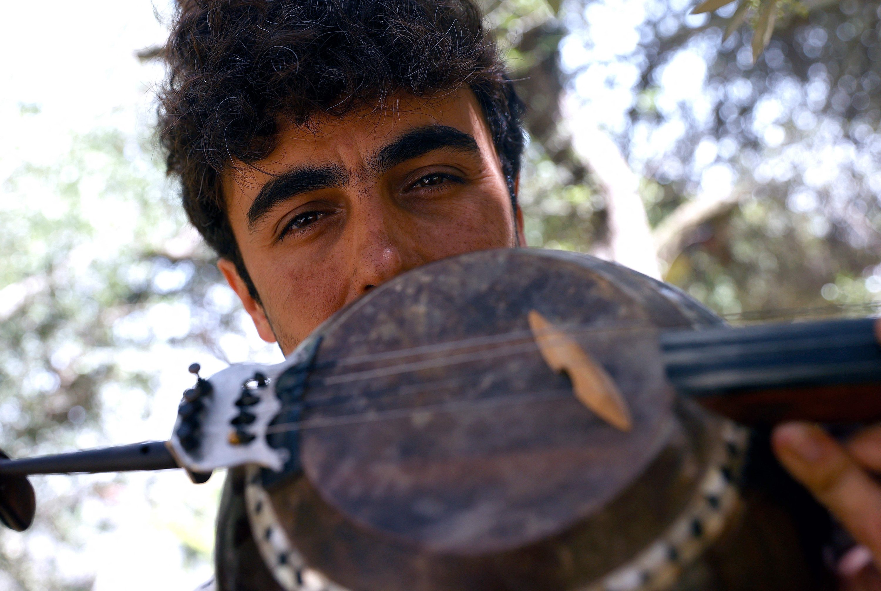 Israeli musician Mark Eliyahu poses for a photo with his "kemenche" bowed string instrument outside his yurt in the northern moshav of Beitt Zaid in northern Israel, April 25, 2022. (AFP)