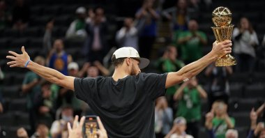 Golden State Warriors guard Stephen Curry celebrates with the Bill Russell Trophy for most valuable player after the game, in Boston, United States, Jun. 16, 2022. (AP PHOTO) 
