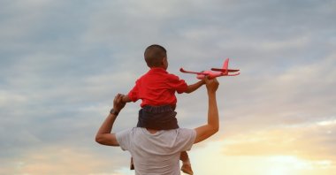A father and son play together outdoors. (Shutterstock Photo)