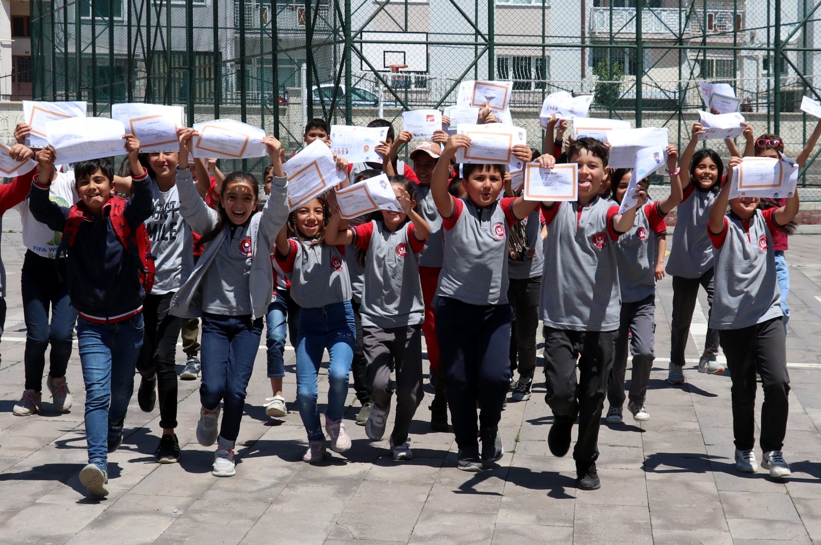 Students holding their report cards leave their school, in Sivas, central Turkey, June 17, 2022. (AA PHOTO)