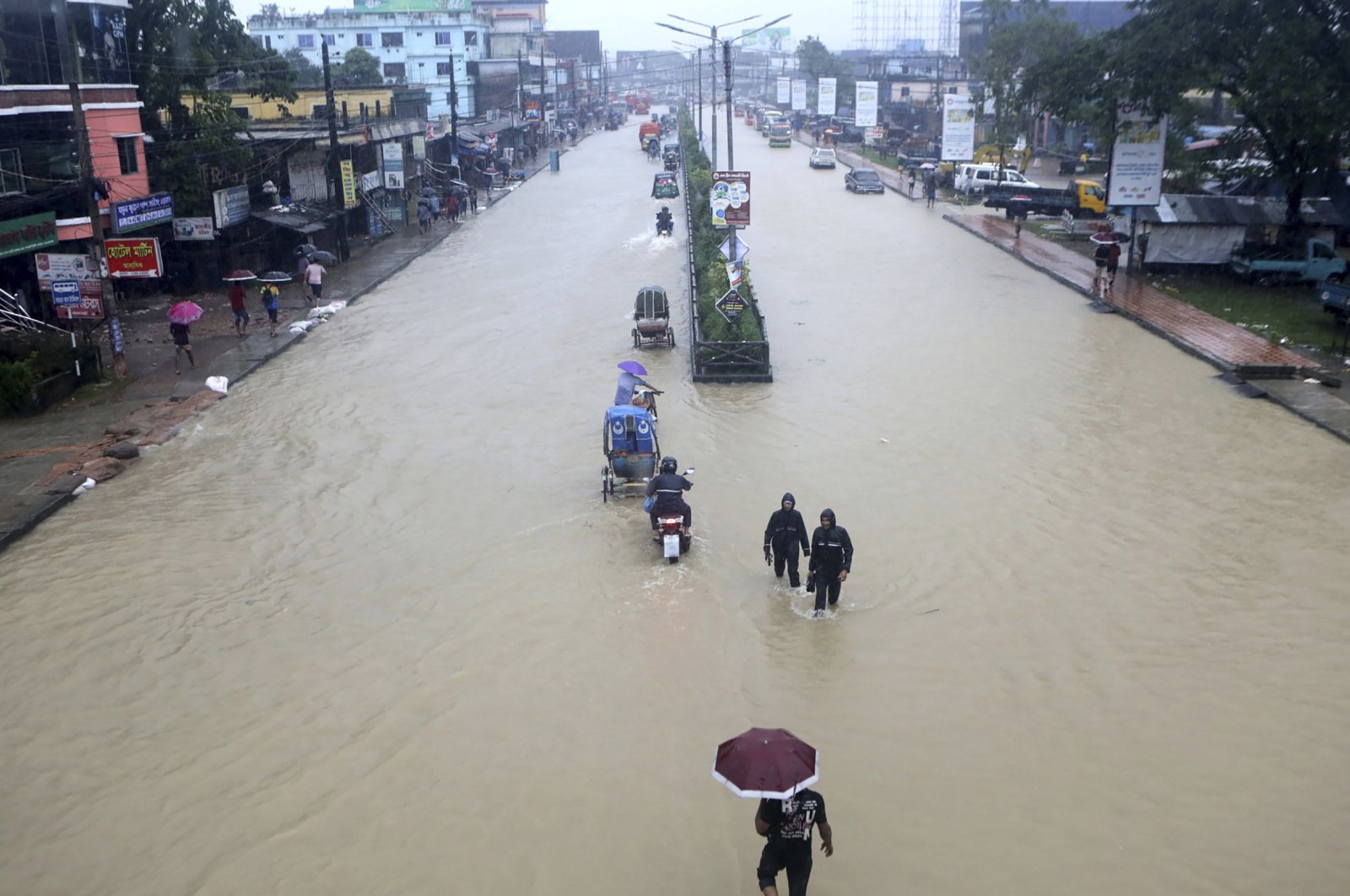 People wade through flooded waters in Sylhet, Bangladesh, June 18, 2022. (AP Photo)