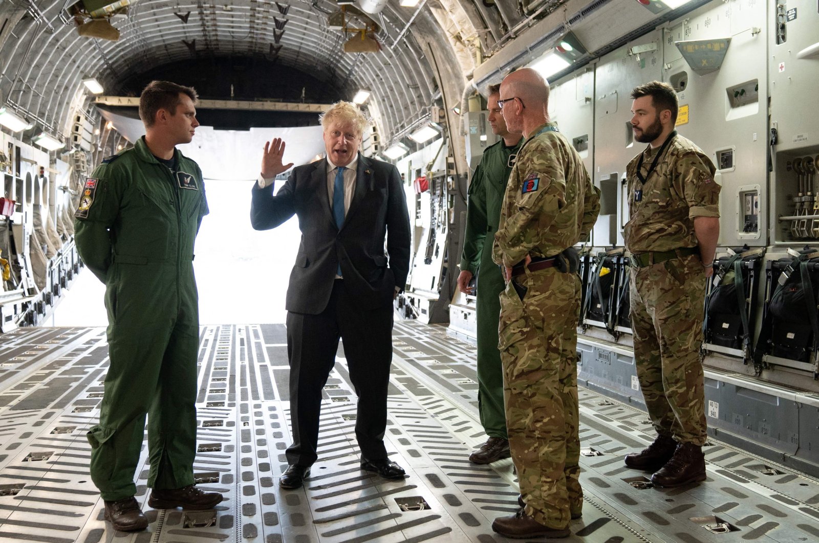 Britain&#039;s Prime Minister Boris Johnson (2nd L) speaks to Air Loadmaster 99 Squadron Sergeant Tom Clare (L), Officer Commanding 99 Squadron Wing commander Will Essex and officer commanding operations wing at RAF Brize Norton Wing commander Andy Hampshire on board a C17, after arriving at RAF Brize Norton, west of London having returned from Kyiv in Ukraine, June 18, 2022. (AFP Photo)