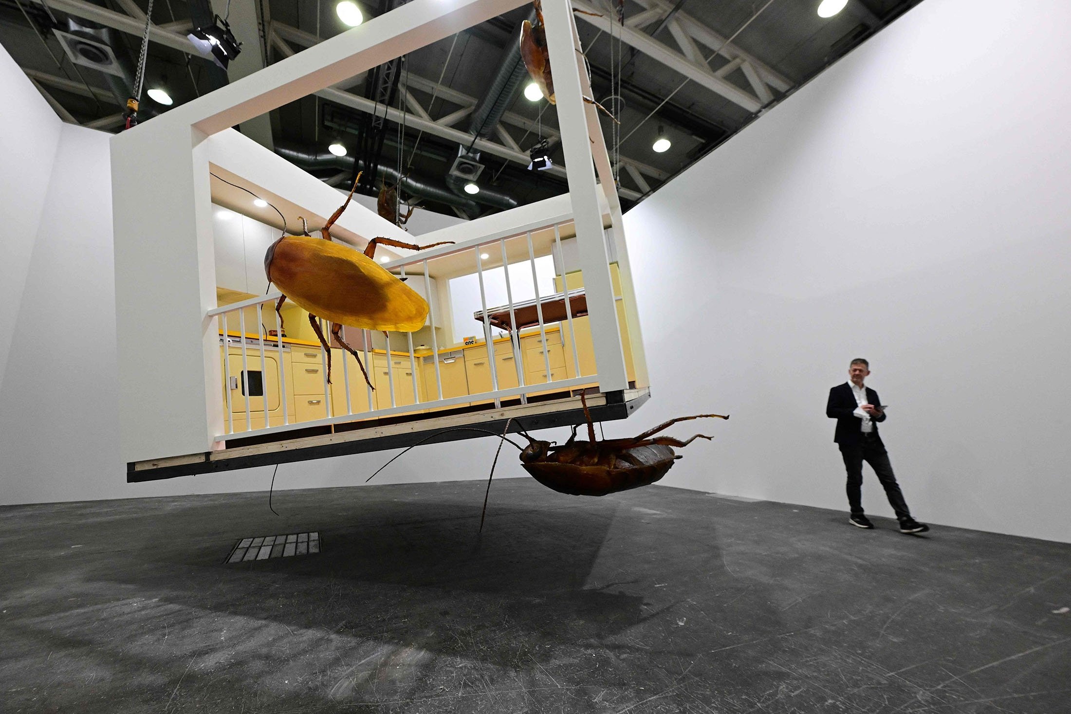 A man looks at Huang Yong Ping's artwork "American kitchen and Chinese" during a preview day of Art Basel, the world's premier modern and contemporary art fair in Basel, Switzerland, June 14, 2022. (AFP Photo)