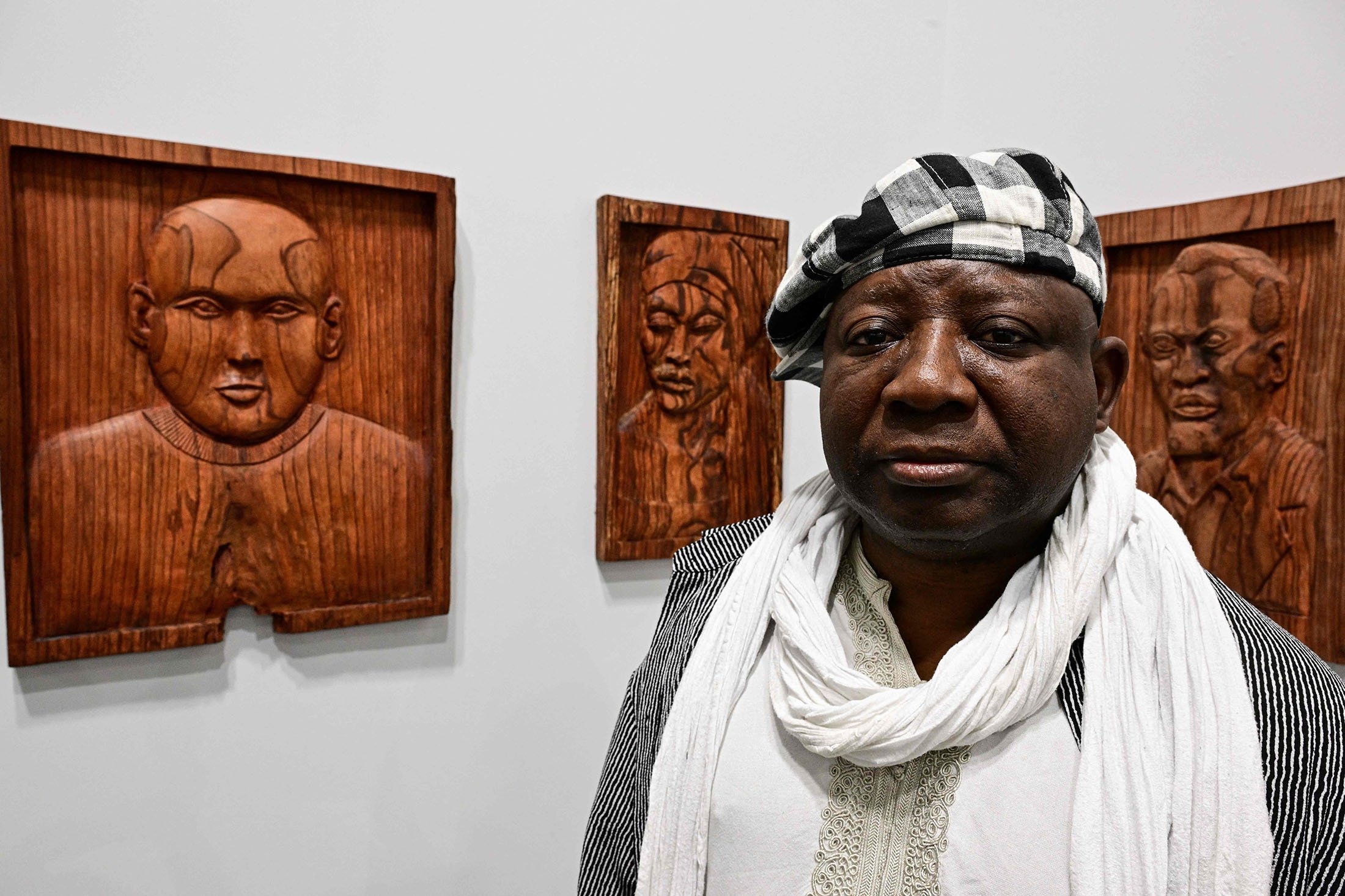 Cameroonian artist Barthelemy Togo poses by his artwork "Bilongue" during a preview day of Art Basel, the world's premier modern and contemporary art fair in Basel, Switzerland, June 14, 2022. (AFP Photo)