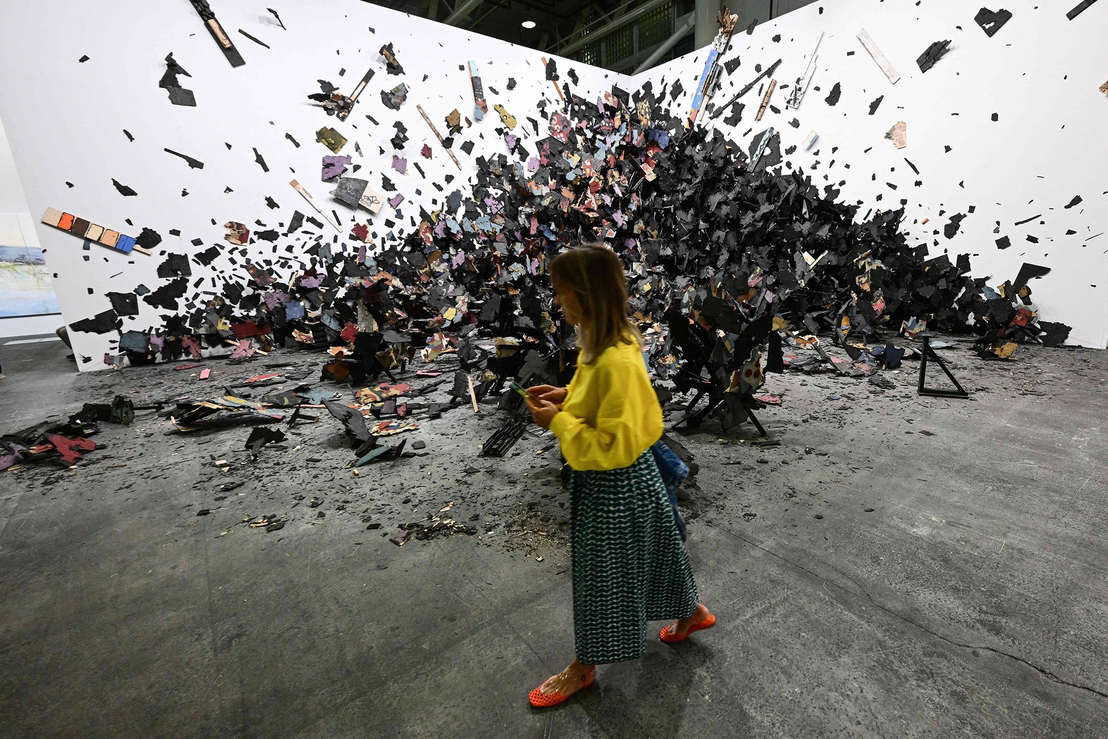 A visitor walks past Leonardo Drew’s artwork "number 341"  during a preview day of Art Basel, the world's premier modern and contemporary art fair in Basel, Switzerland, June 14, 2022. (AFP Photo)