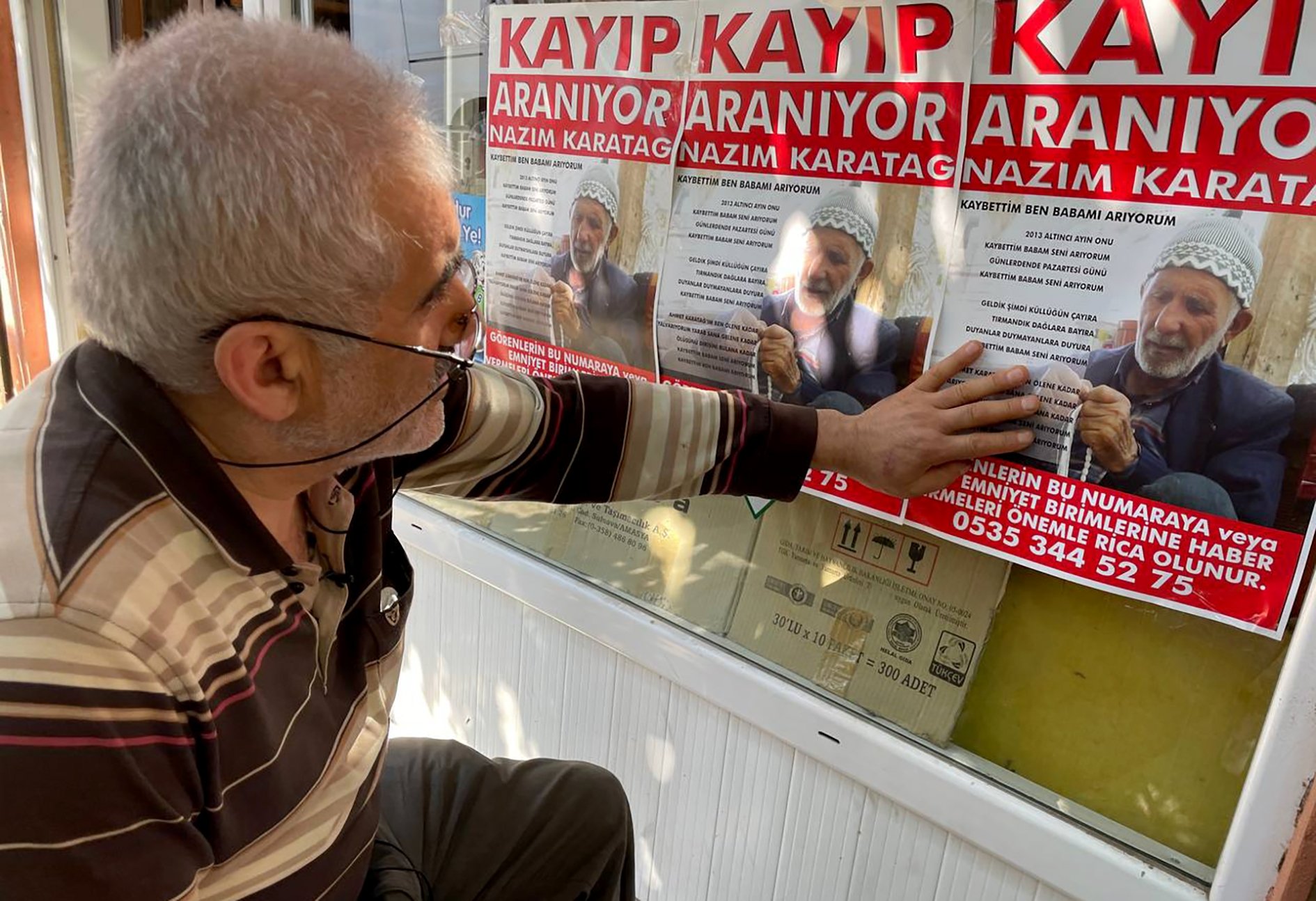 Ahmet Karatağ touches a poster of his missing father, in Istanbul, Turkey, June 19, 2022. (AA Photo)
