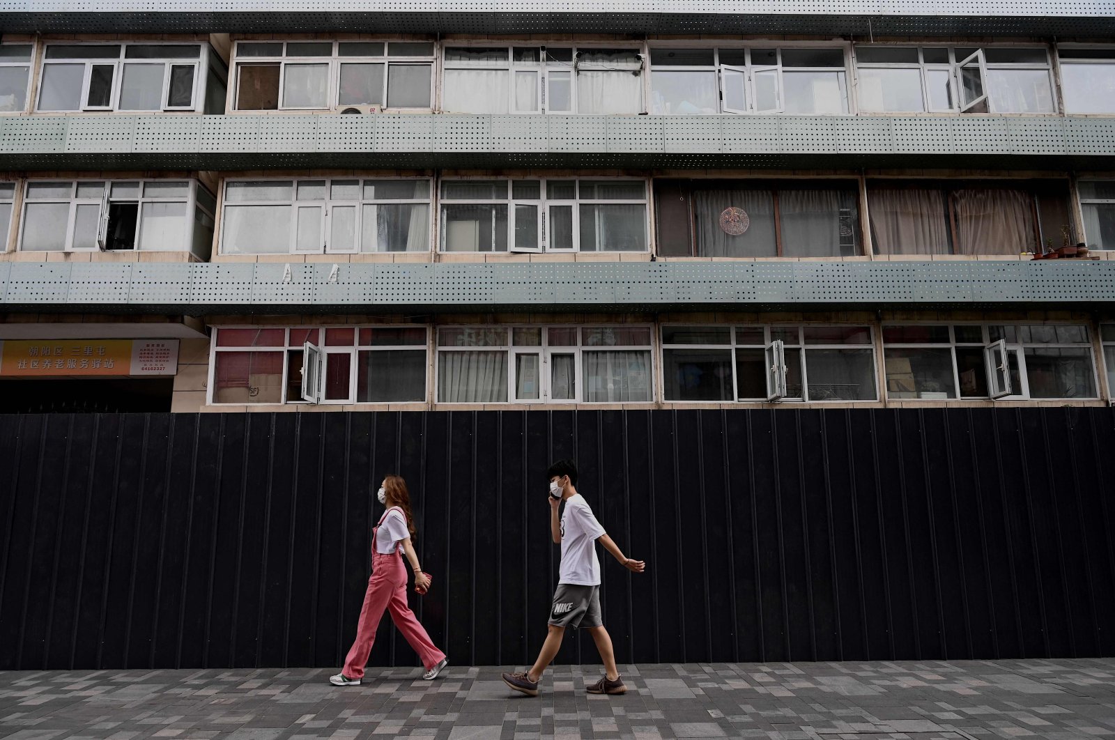 People walk past a residential area under lockdown due to COVID-19 restrictions in Beijing, China, June 15, 2022. (AFP Photo)