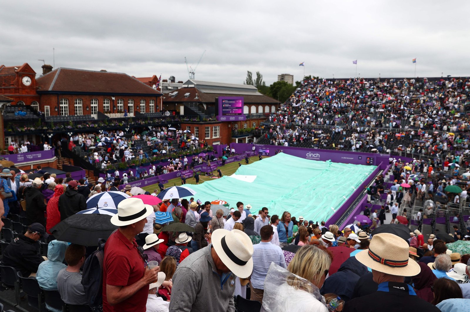 Spectators start to leave and the covers are pulled over the court as rain returns to disrupt the men&#039;s singles semifinal tennis match between Matteo Berrettini and Botic van de Zandschulp on Day 6 of the cinch ATP Championships at Queen&#039;s Club, west London, U.K., June 18, 2022. (AFP Photo)