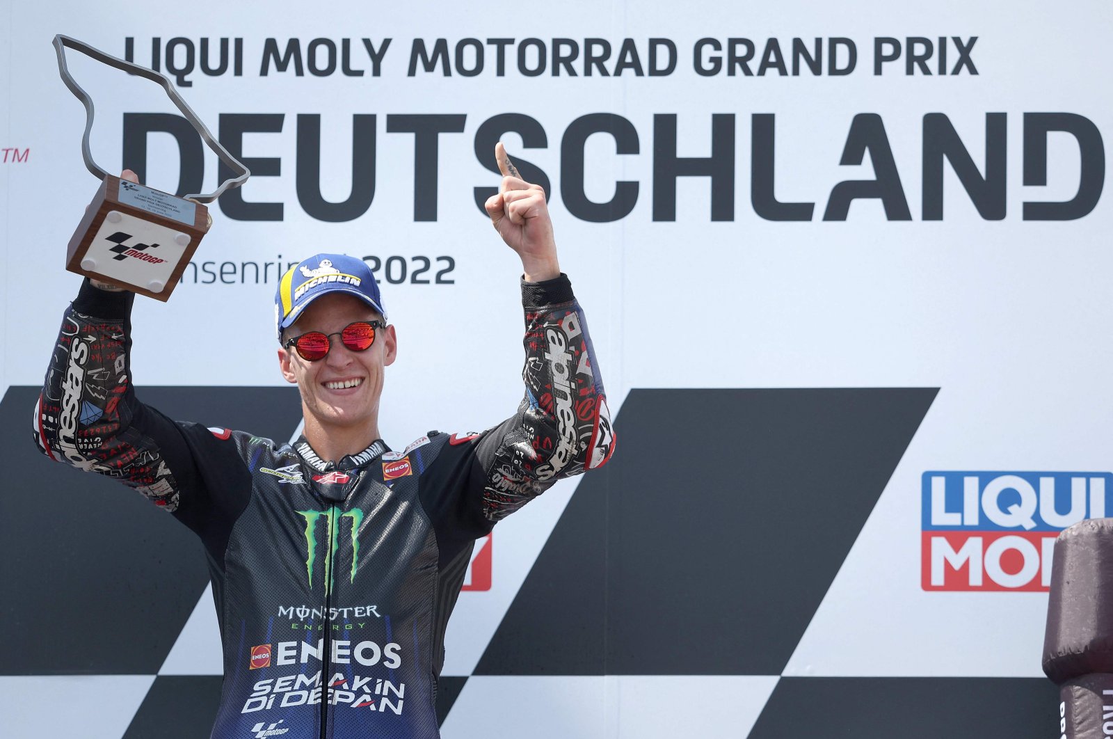 Monster Energy Yamaha&#039;s French rider Fabio Quartararo celebrates on the podium after winning the German MotoGP Grand Prix, Hohenstein-Ernstthal, Germany, June 19, 2022. (AFP Photo)
