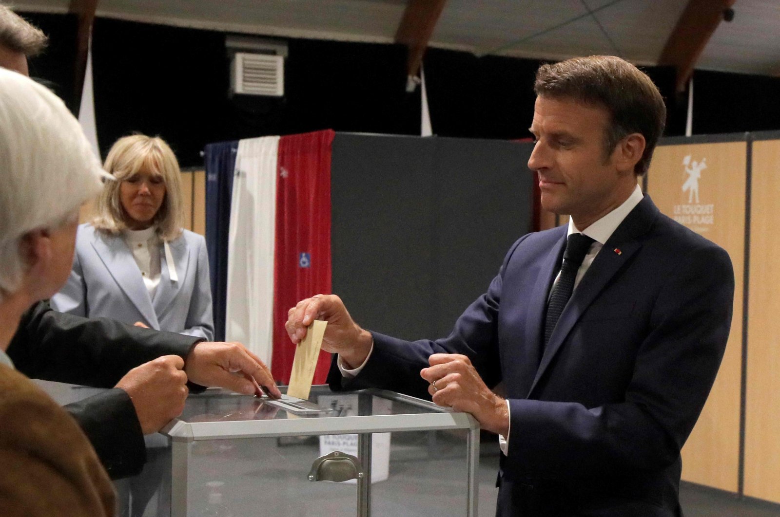France&#039;s President Emmanuel Macron (R) casts his ballot next to his wife Brigitte Macron during the second stage of French parliamentary elections at a polling station in Le Touquet, northern France, June 19, 2022. (AFP Photo)