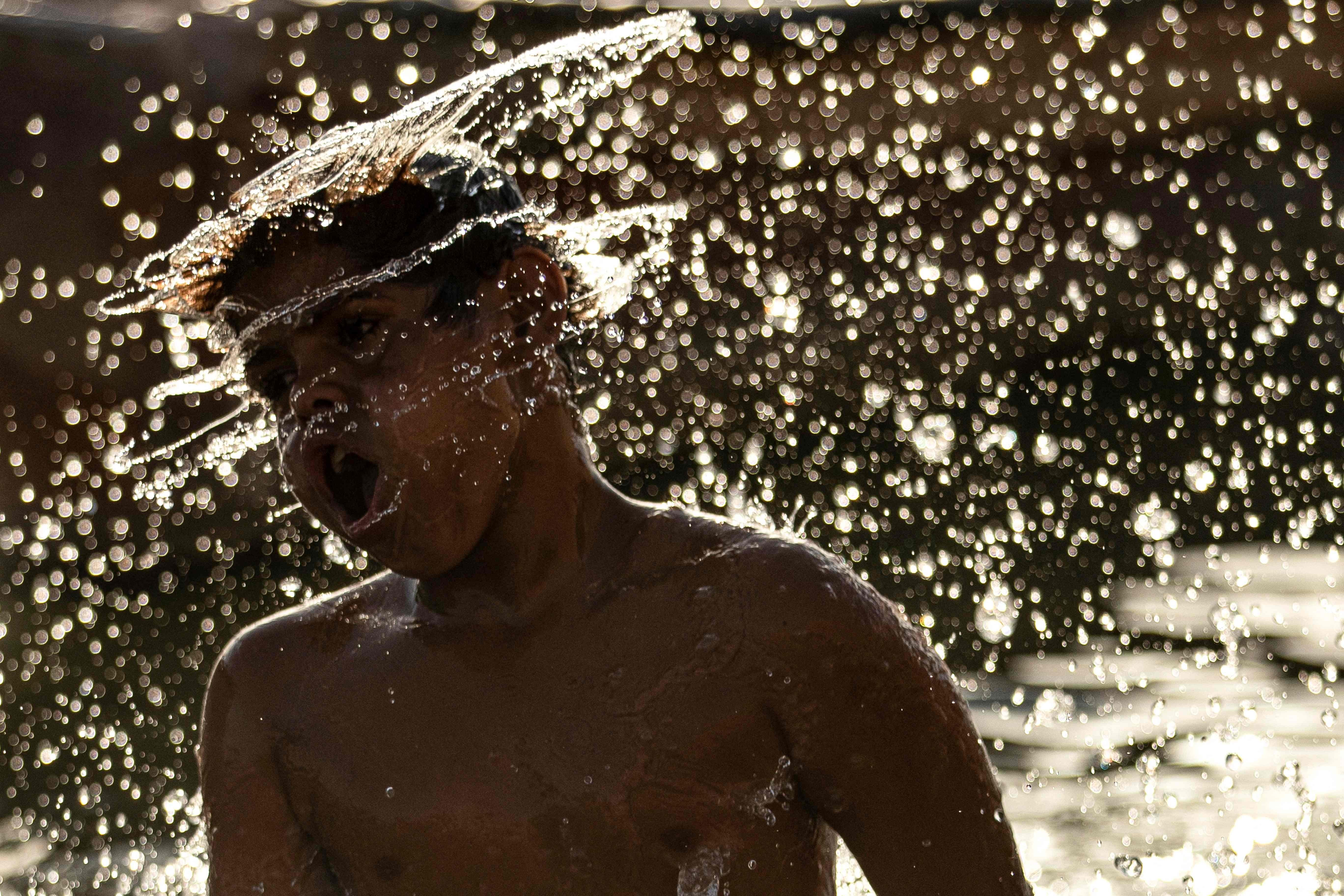 A boy cools off in the Shatt al-Arab waterway, formed at the confluence of the Euphrates and Tigris rivers, in Iraq&#039;s southern city of Basra near sunset, June 18, 2022. (AFP Photo)