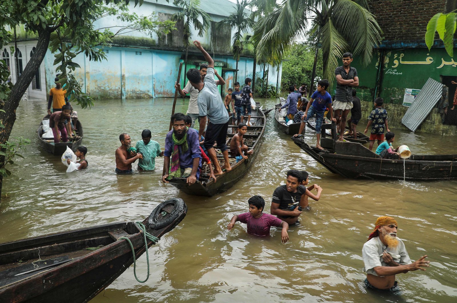 People gather to collect food aid in a flooded residential area following heavy monsoon rainfalls in Companiganj, Bangladesh, June 20, 2022. (AFP Photo)