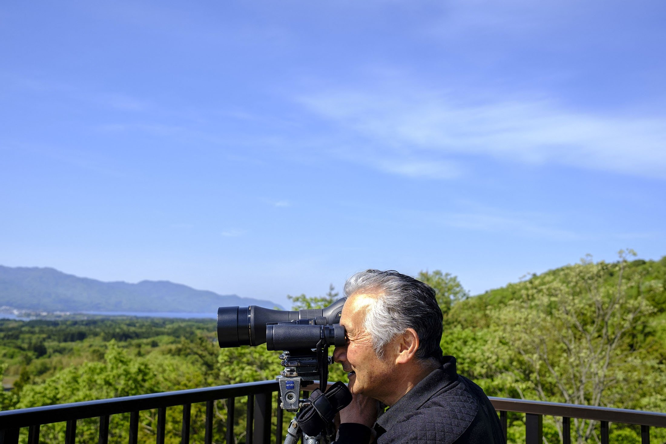 Masaoki Tsuchiya looks for toki birds from an observatory on Sado island, Niigata prefecture, Japan, May 8, 2022. (AFP Photo)