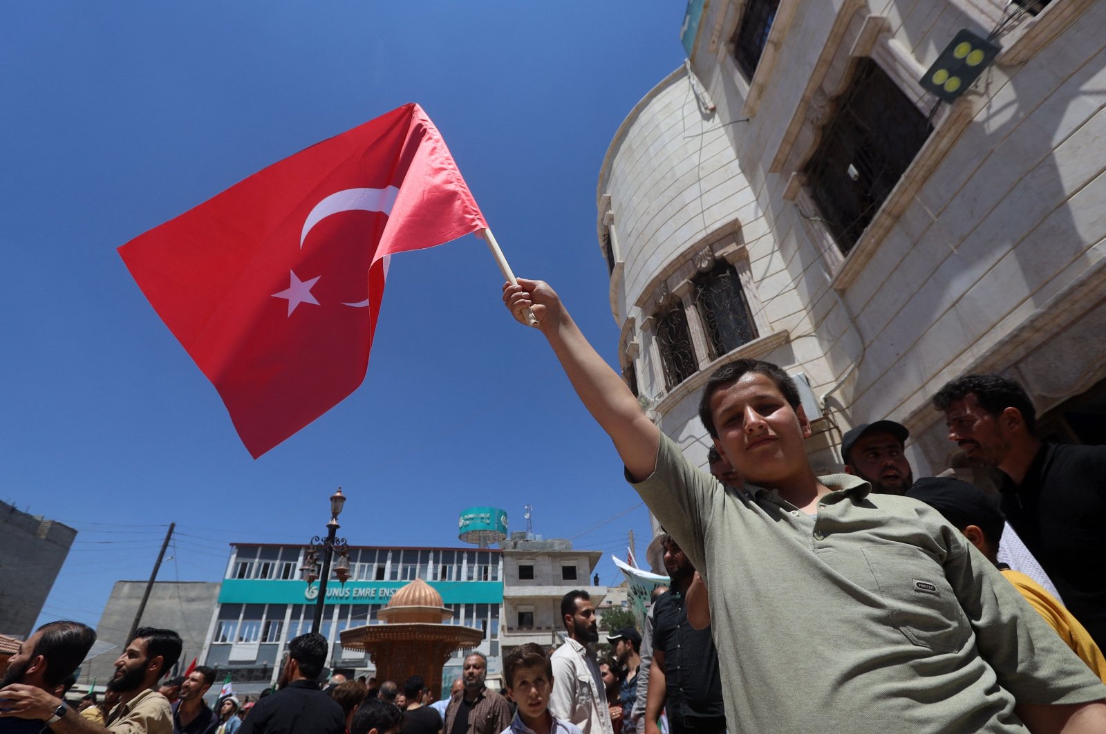 A young Syrian raises a Turkish flag as he participates in a rally in the border town of Azaz in the opposition-held north of the Aleppo province, northern Syria, June 5, 2022. (AFP)
