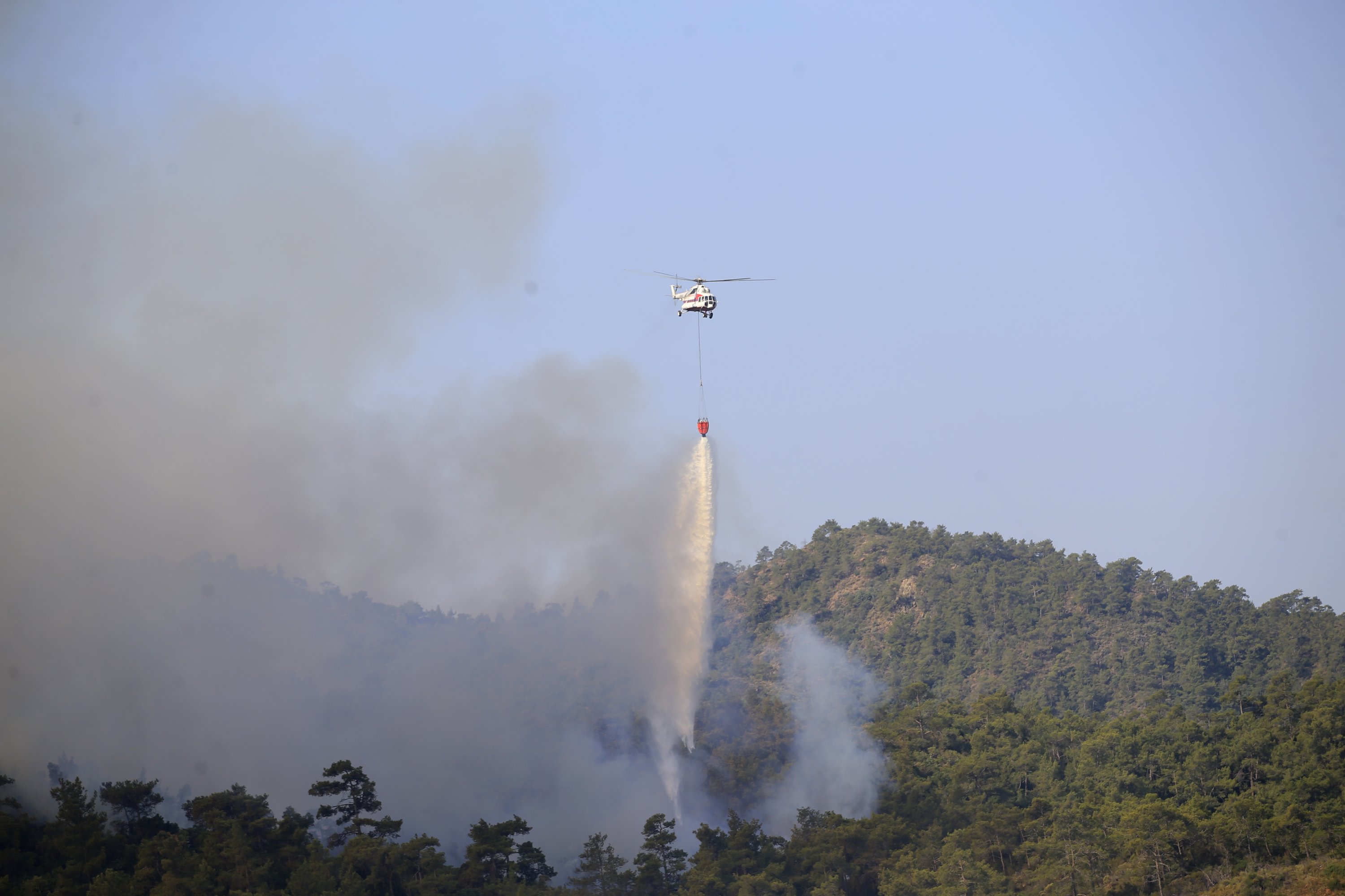 A helicopter pours water on burning areas in Marmaris, Muğla, southwestern Turkey, June 22, 2022. (AA PHOTO)