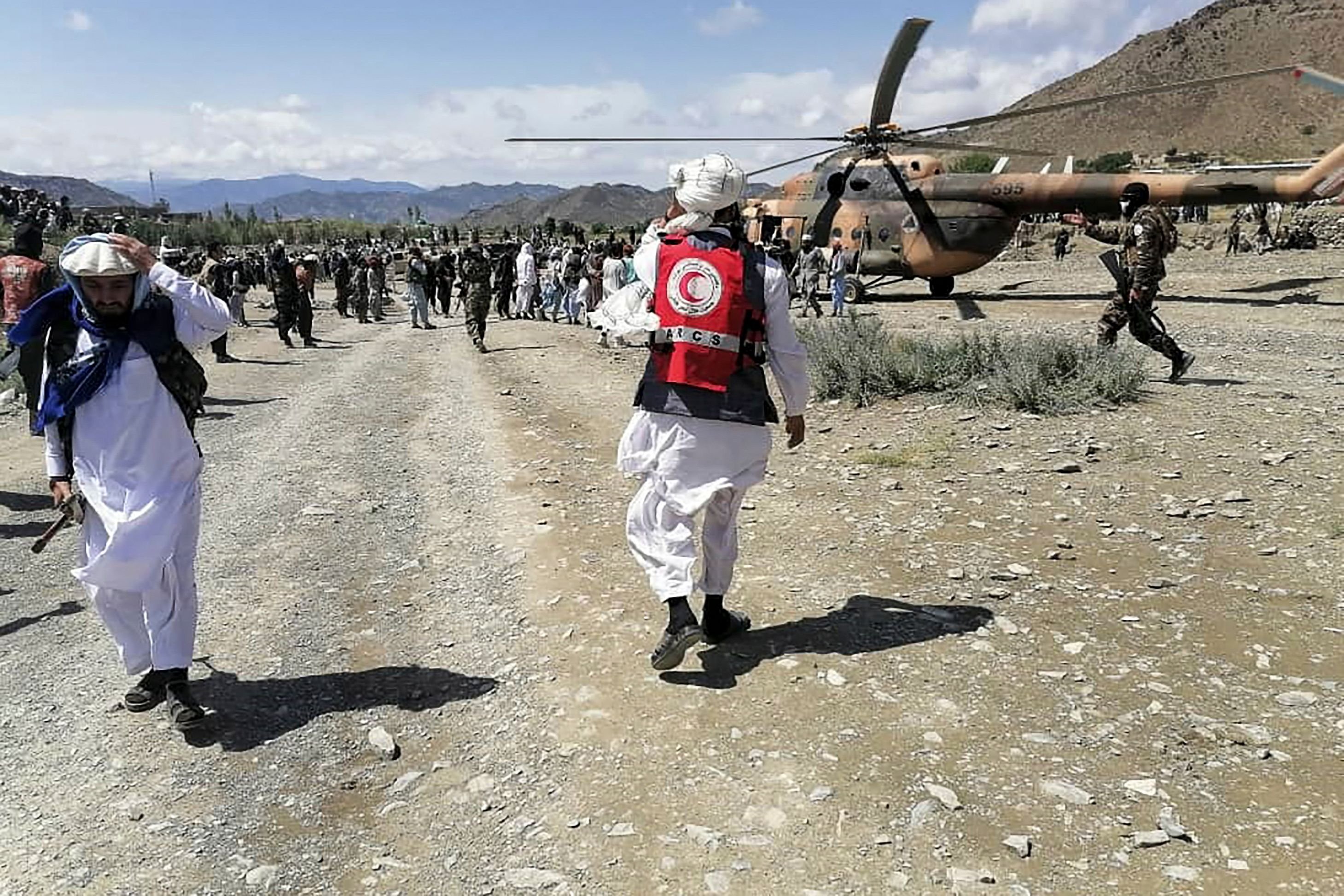 In this photo released by the state-run Bakhtar News Agency, soldiers and Afghan Red Crescent Society officials gather near a helicopter at an earthquake-hit area in the Gayan district, Paktika, eastern Afghanistan, June 22, 2022. (AFP Photo)