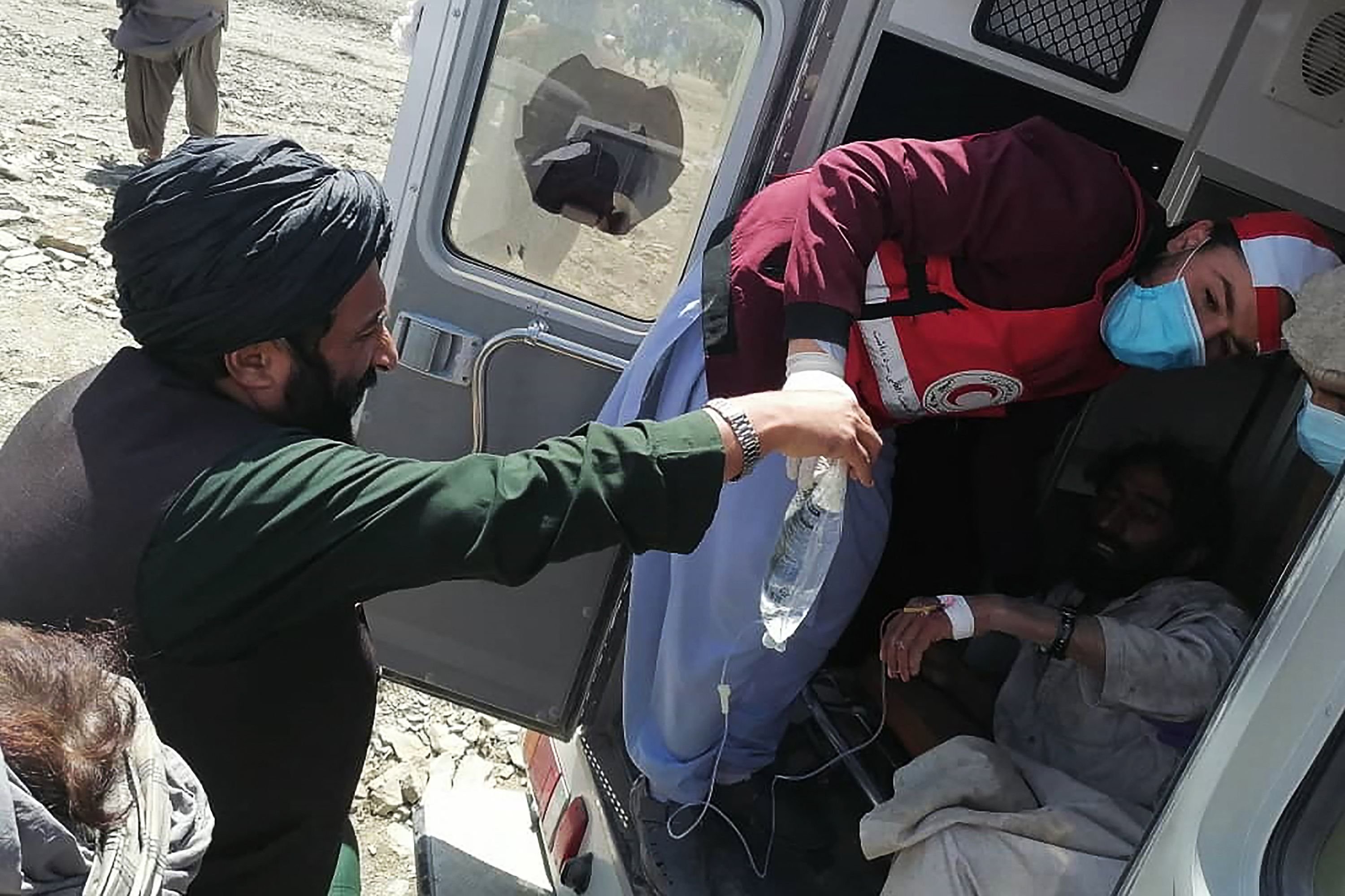 In this photo released by the state-run Bakhtar News Agency, a member of the Afghan Red Crescent Society provides medical treatment to a victim following an earthquake in the Gayan district, Paktika, eastern Afghanistan, June 22, 2022. (AFP Photo)