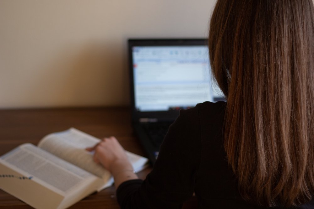 A closeup of a translator working with a translation tool and dictionary. (Shutterstock Photo)