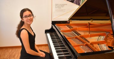 Fifteen-year-old Turkish pianist Ayşe Cemre Ağırgöl poses with her piano.