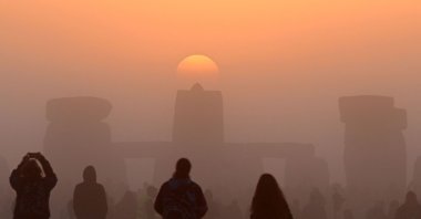 Revelers celebrate the summer solstice as the sun rises at Stonehenge, near Amesbury, in Wiltshire, U.K., June 21, 2022. (AFP Photo)