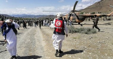 In this photo released by the state-run Bakhtar News Agency, soldiers and Afghan Red Crescent Society officials gather near a helicopter at an earthquake-hit area in the Gayan district, Paktika, eastern Afghanistan, June 22, 2022. (AFP Photo)