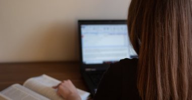 A closeup of a translator working with a translation tool and dictionary. (Shutterstock Photo)