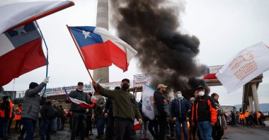 Miners block access to the Ventanas smelter during the start of an "undefined" national strike of workers of the state mining company Codelco in Las Ventanas, in the bay of Quintero and Puchuncavi, about 140 kilometers west of Santiago, Chile, June 22, 2022. (Photo by Aton Chile via AFP)