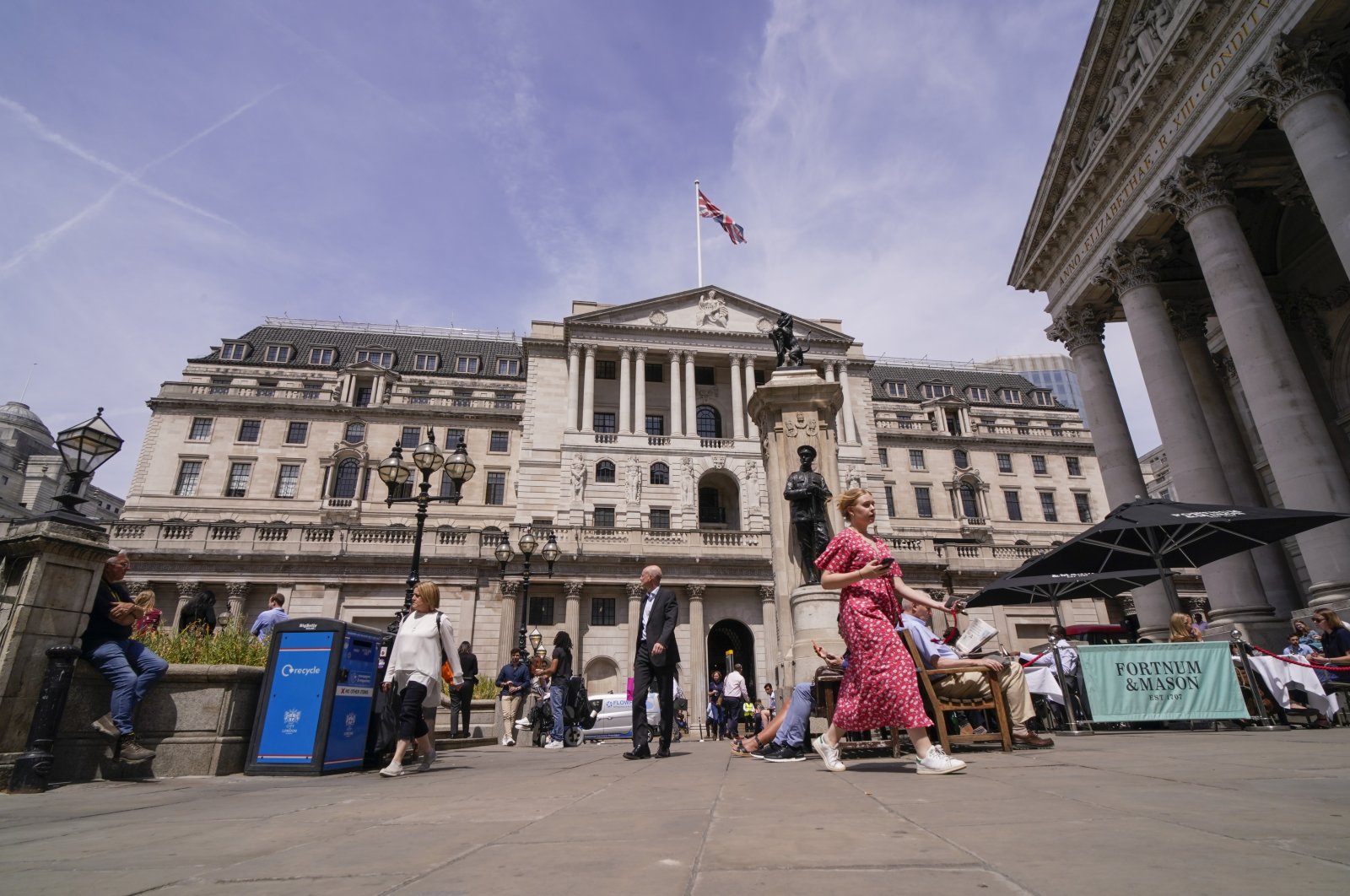 People walk outside the Bank of England, in the financial district known as The City, in London, U.K., June 16, 2022. (AP Photo)