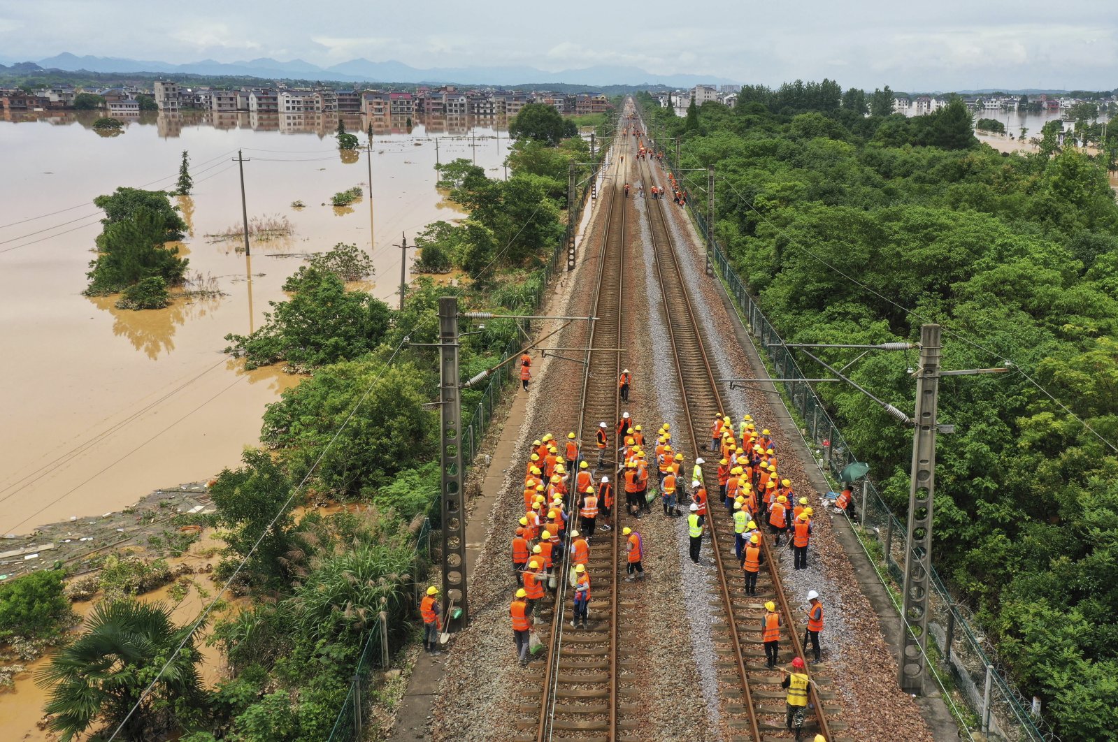Workers gather along a section of flooded railway in Shangrao, Jiangxi province, China, June 21, 2022. (AP Photo)