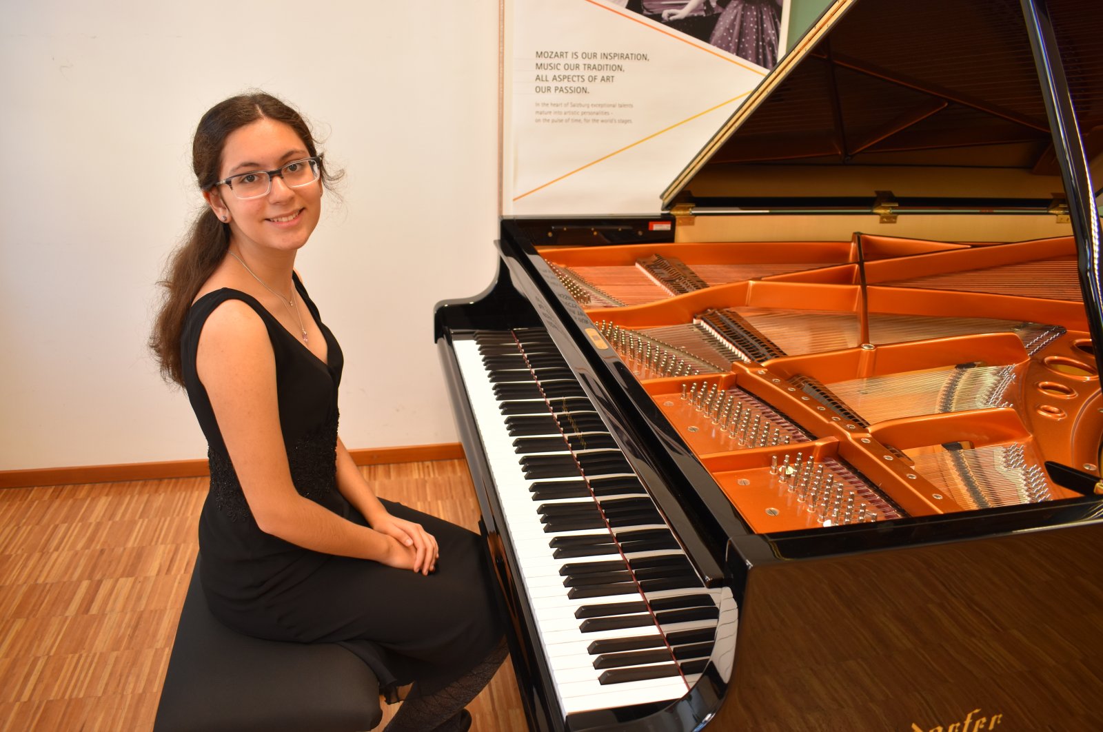 Fifteen-year-old Turkish pianist Ayşe Cemre Ağırgöl poses with her piano.