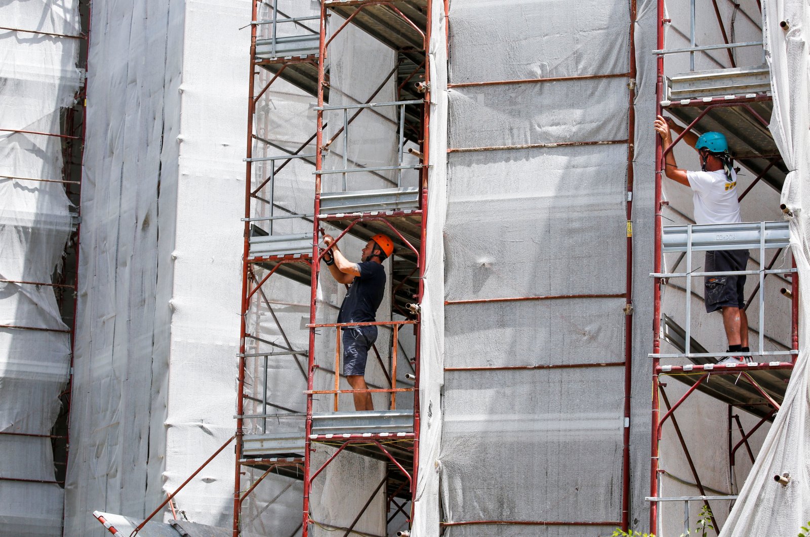 Builders from Pierluigi Fusco&#039;s firm work at the construction site of an energy-saving building, making apartments more energy efficient under government &quot;superbonus&quot; incentives, in Caserta, southern Italy, June 21, 2022. (Reuters Photo)