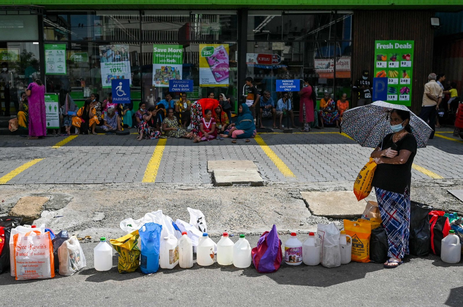 People queue up to buy kerosene for domestic use at a supply station in Colombo, Sri Lanka, May 26, 2022. (Photo by Ishara S. Kodikara / AFP)