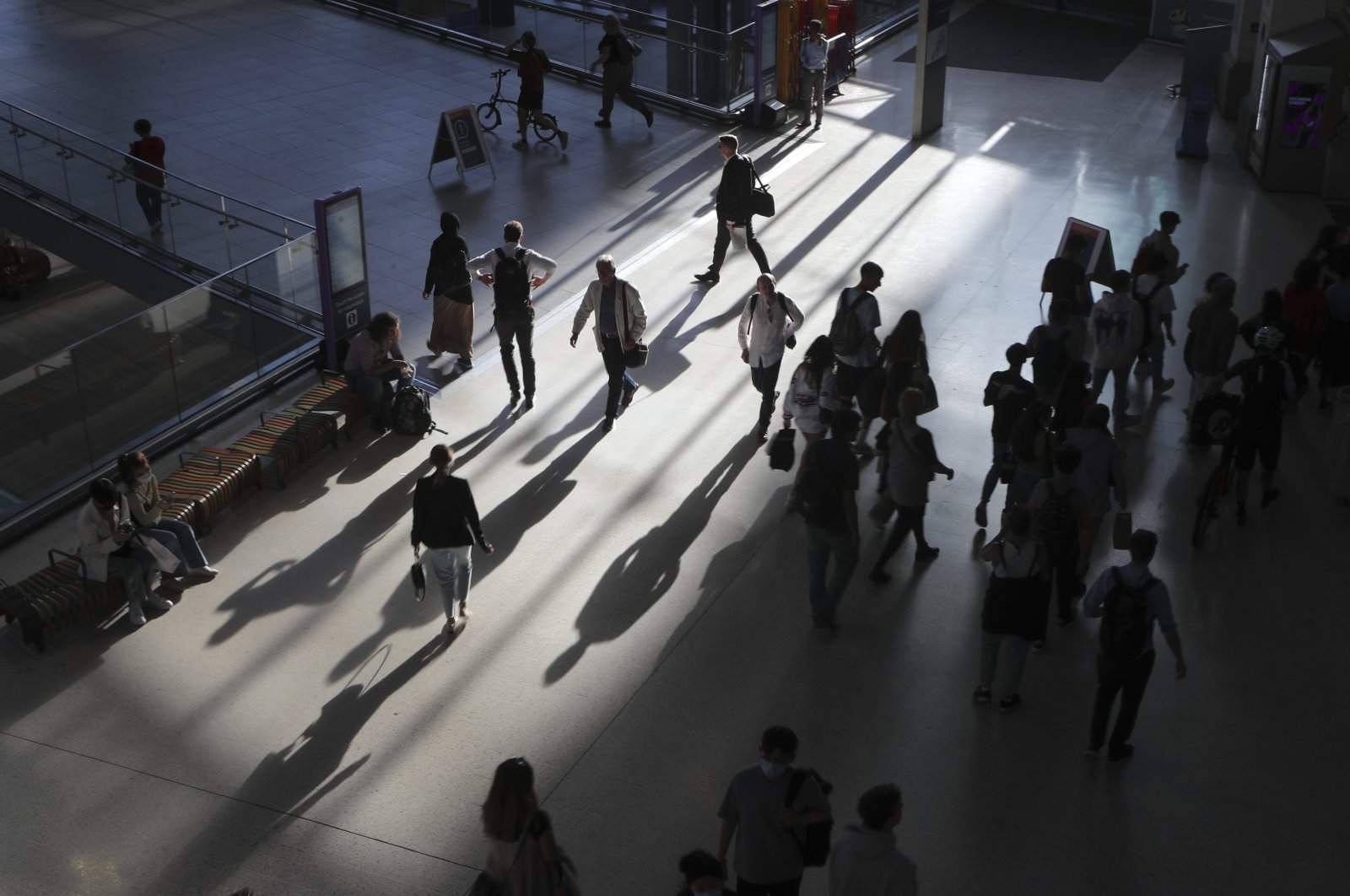 Commuters are silhouetted in the evening light as they walk inside Waterloo station in London, U.K., June 20, 2022. (AP Photo)
