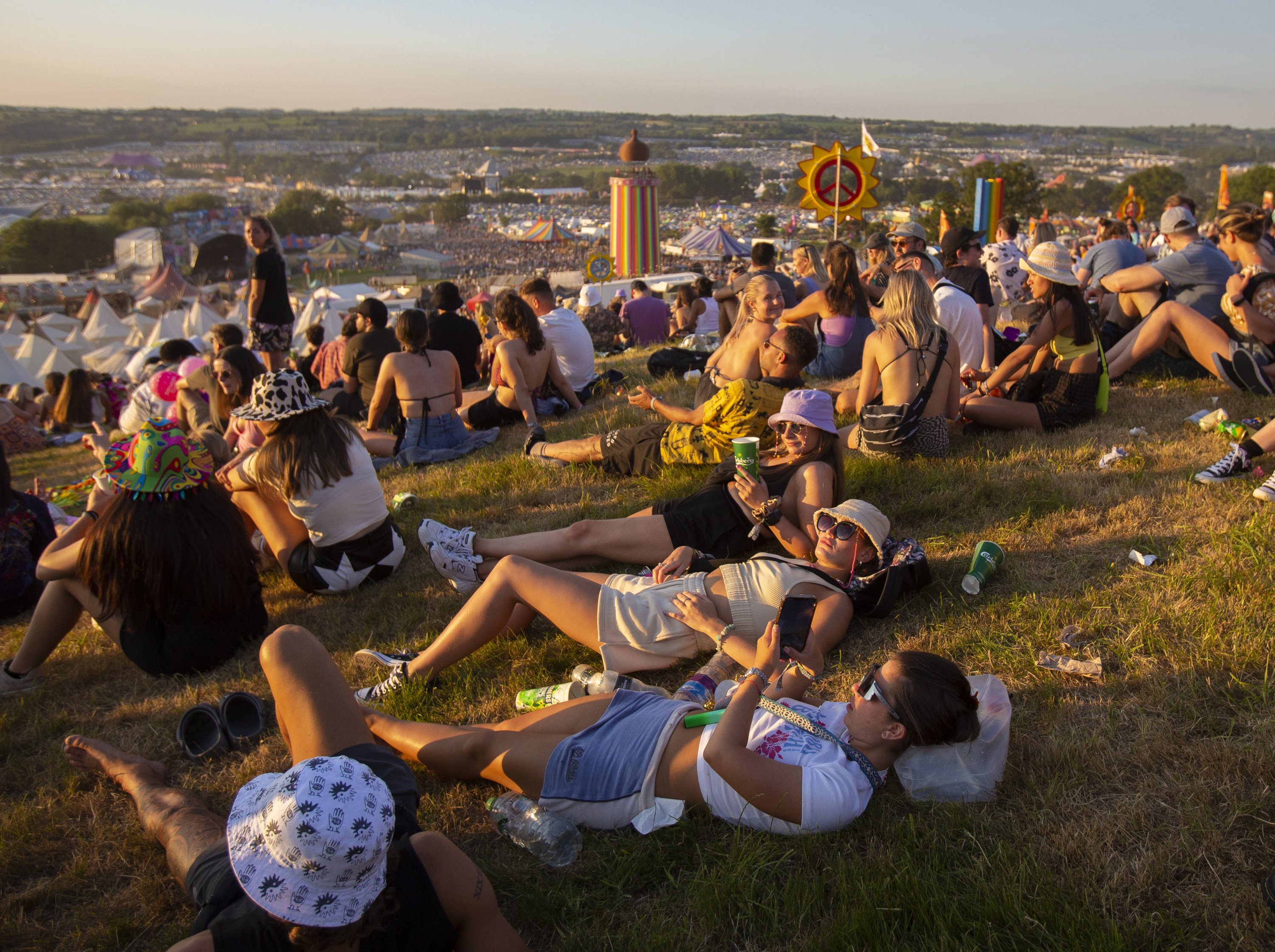 Peserta festival menyaksikan matahari terbenam pada hari pertama Festival Glastonbury, Pilton, Inggris, 22 Juni 2022. (EPA)