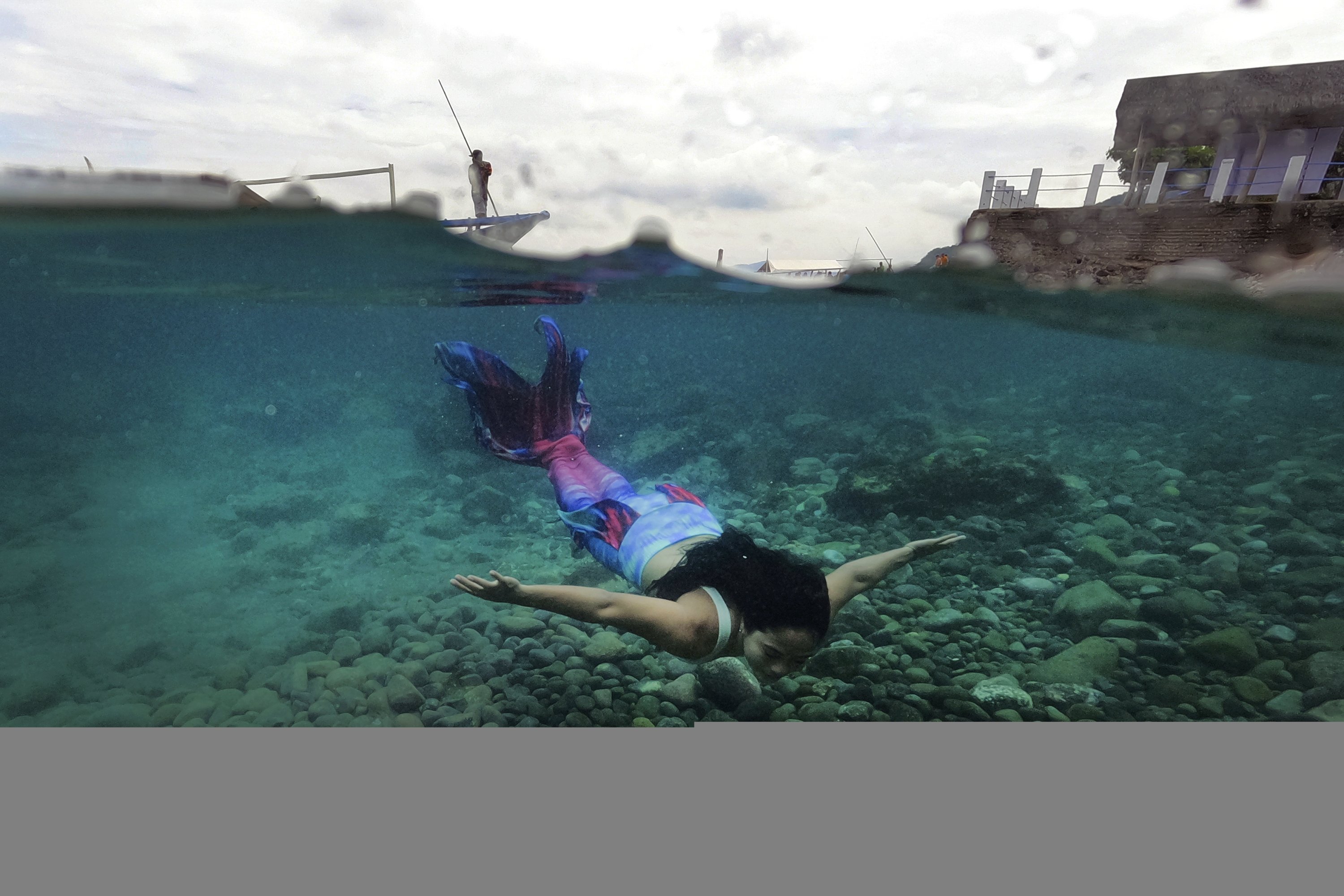 Filipina Jennica Secuya berenang dalam setelan putri duyung selama kelas putri duyung di Mabini, provinsi Batangas, Filipina, 22 Mei 2022. (AP Photo)