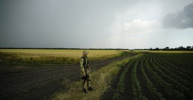  A Russian soldier guards an area next to a field of wheat as journalists work in the Zaporizhzhia region in an area under Russian military control, southeastern Ukraine, June 14, 2022. (AP Photo)
