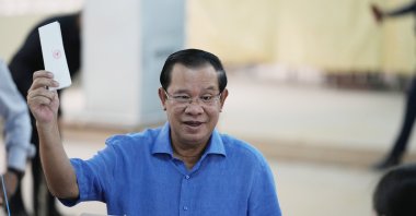 Cambodian Prime Minister Hun Sen, of the Cambodian People's Party (CPP), holds his ballot before dropping it into a ballot box at a polling station in Takhmua in Kandal province, southeast of Phnom Penh, Cambodia, June 5, 2022. (AP Photo)