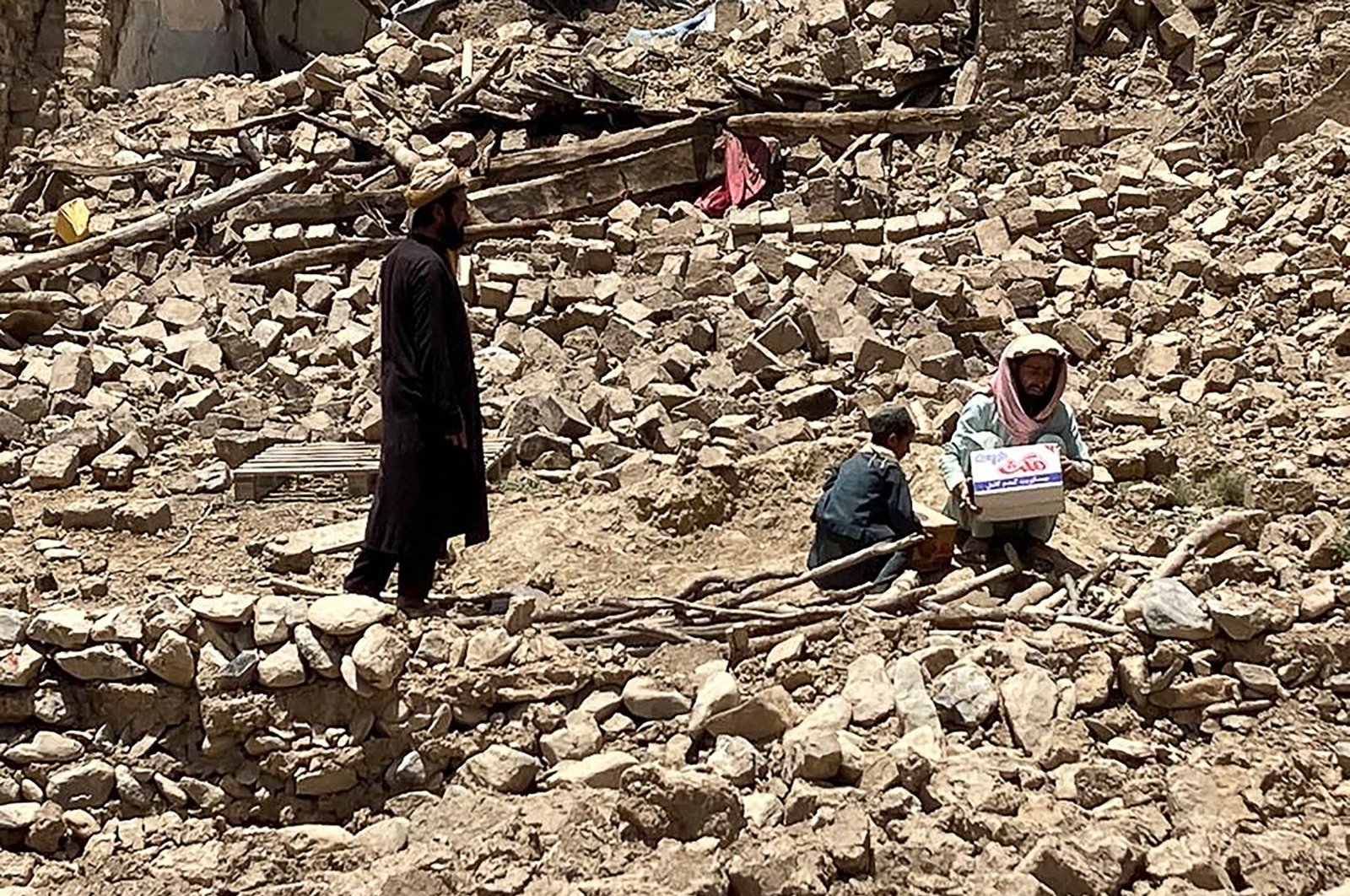 Men stand amid the rubble of damaged houses following an earthquake in Bermal district, in Paktika province, Afghanistan, June 23, 2022. (AP Photo)