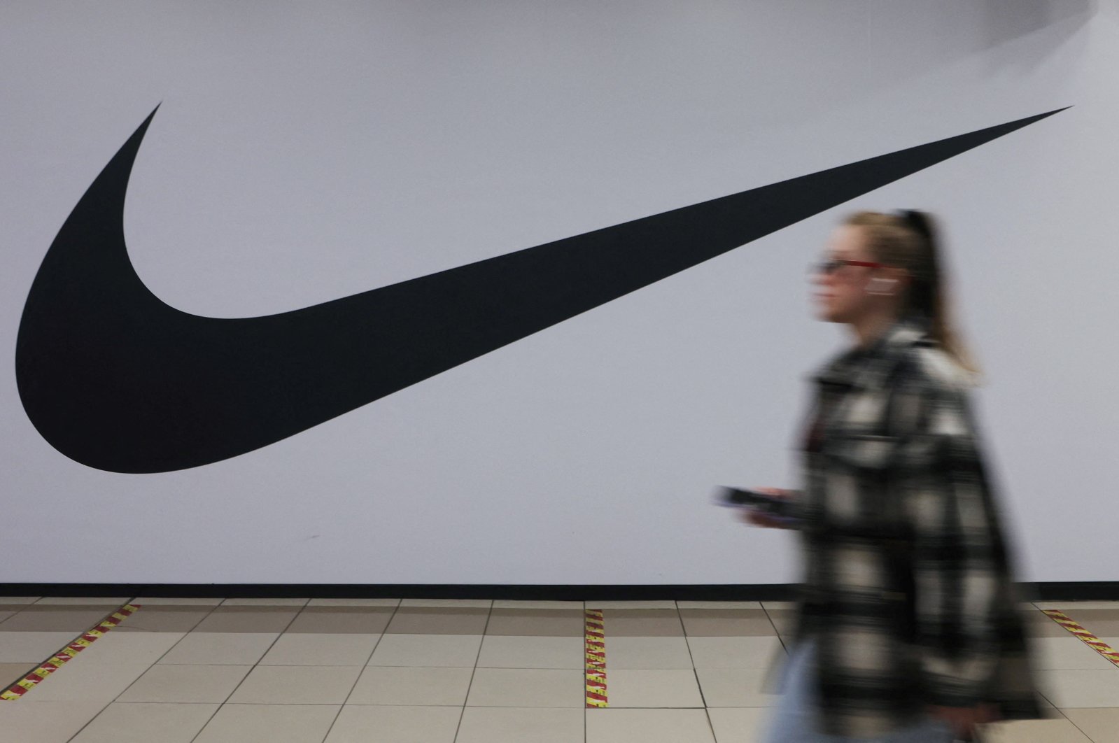 A woman walks past a closed store of the sporting goods retailer Nike at a shopping mall in Saint Petersburg, Russia, May 25, 2022. (Reuters Photo)