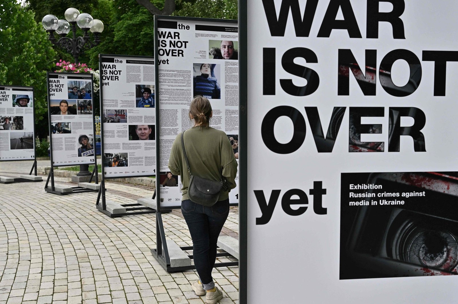 A woman visits the photo exhibition &quot;The War Is Not Over Yet&quot; opened in the Taras Shevchenko park in Kyiv, Ukraine, June 23, 2022. (AFP Photo)