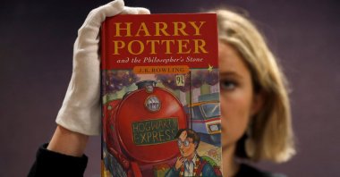 One of the first-ever copies of "Harry Potter and the Philosopher's Stone" by J.K. Rowling, is held by a staff member at Bonhams auctioneers, ahead of the Fine Books, Manuscripts, Atlases and Historical Photographs sale in London, Britain March 27, 2019.  (REUTERS Photo)