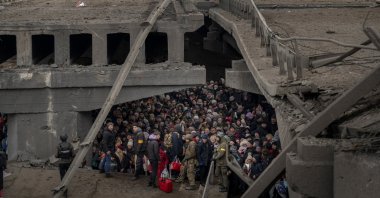 Ukrainians crowd under a destroyed bridge as they try to flee by crossing the Irpin River on the outskirts of Kyiv, Ukraine, March 5, 2022. (AP Photo)