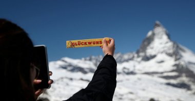 A tourist takes a picture of a Toblerone in front of the Matterhorn mountain at the Gornergrat in Zermatt, Switzerland June 2, 2019. (Reuters Photo)