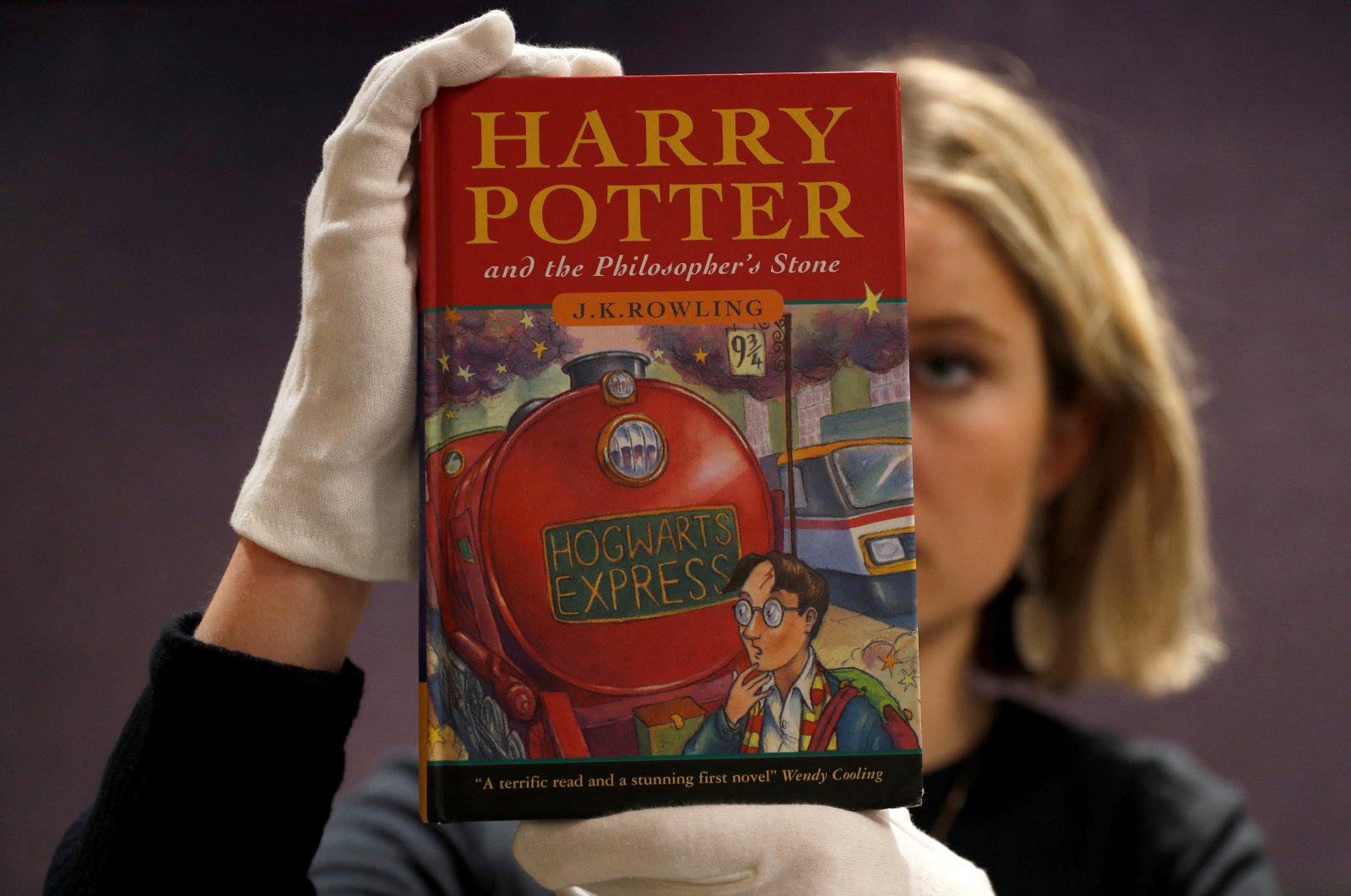 One of the first-ever copies of &quot;Harry Potter and the Philosopher&#039;s Stone&quot; by J.K. Rowling, is held by a staff member at Bonhams auctioneers, ahead of the Fine Books, Manuscripts, Atlases and Historical Photographs sale in London, Britain March 27, 2019.  (REUTERS Photo)