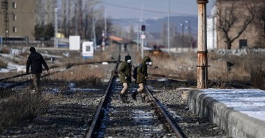 Boys walk on railtracks near Akyaka Train station on January 9, 2022 in Akyaka district of Kars city, eastern Turkey, near the Turkish-Armenian border. (AFP Photo)
