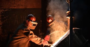 Workers pour metal at a private Berdyansk foundry in Berdyansk, amid the ongoing Russian military action in Ukraine, June 14, 2022. (AFP Photo) 