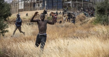 Migrants run on Spanish soil after crossing the fences separating the Spanish enclave of Melilla from Morocco in Melilla, Spain, Friday, June 24, 2022. (AP Photo)